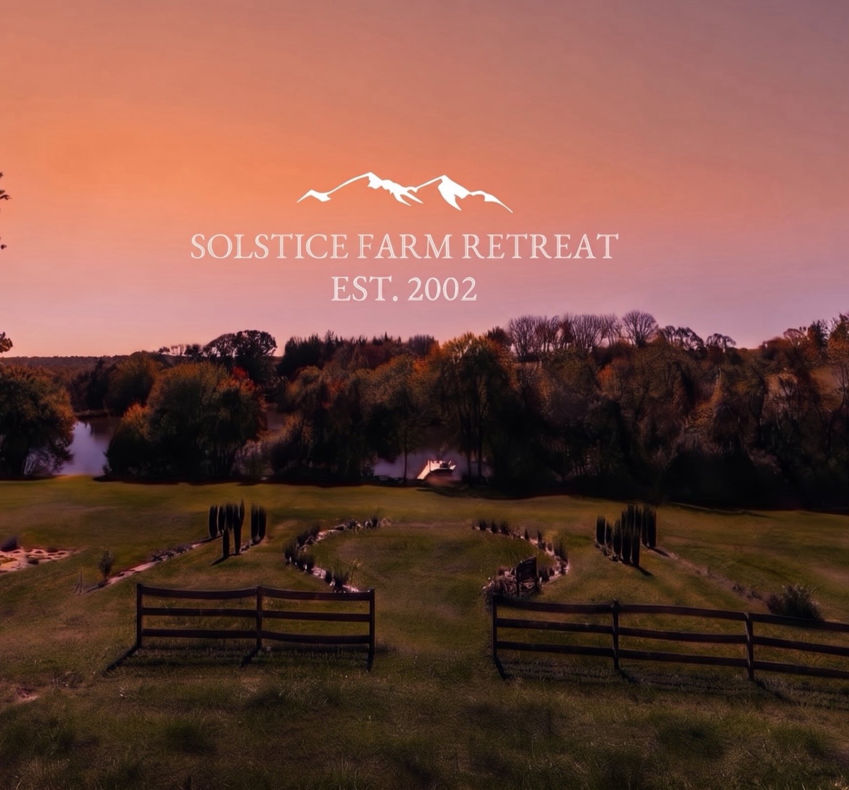 Solstice Farm Retreat at dusk: the lawn running down to the pond and dock, with the logo set against an orange and violet sky